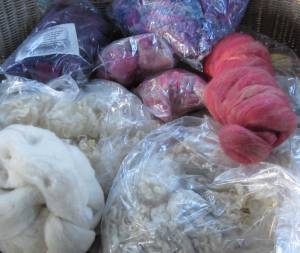 shows bags of fleece, piles of roving