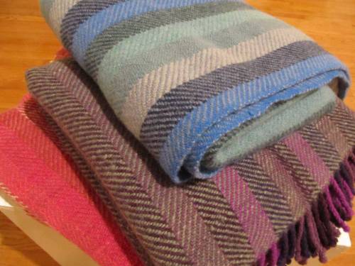 rust blanket at lower left, purple and green in middle, and blues and greens on top