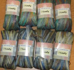 two rows of four skeins of the yarn in different shades of blue.