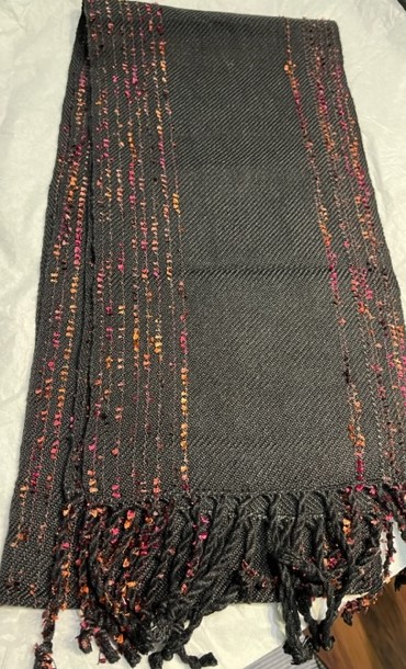 Show black scarf with random Little Flowers threads in yellow and reds along both sides of the scarf. Scarf is folded, so lower side shows the Little Flowers on the back side of the scarf.
